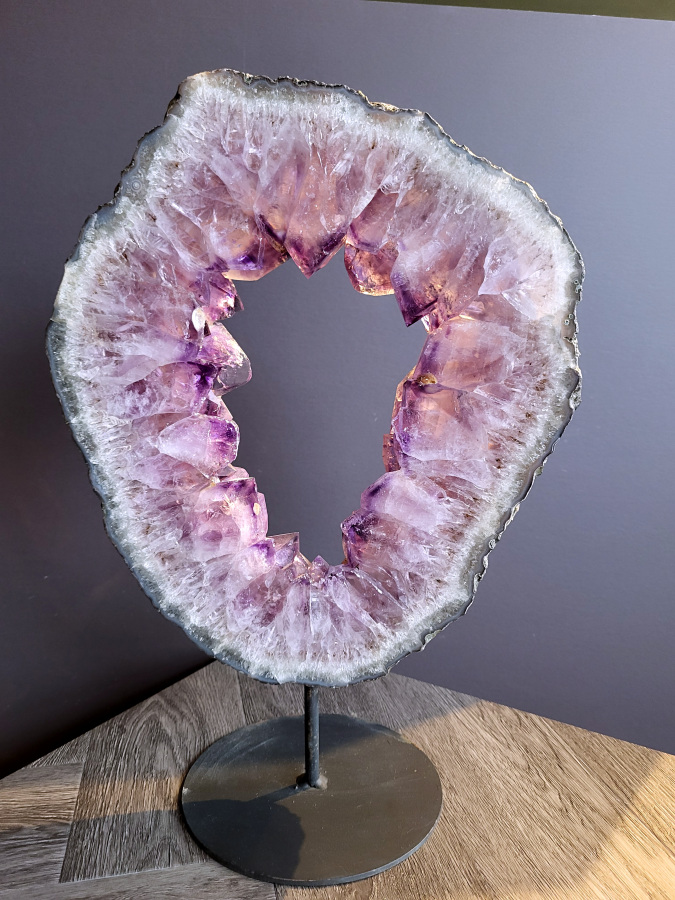 <strong>Amethist, Amethist Portaal, 7kg, 46cm hoog, 317,- euro, nr. 3</strong>

<strong>Amethist is een paarse variëteit van kwarts, bekend om zijn kalmerende en spirituele eigenschappen.</strong> De kleur varieert van licht lila tot diep violet en wordt veroorzaakt door sporen van ijzer en andere elementen. Amethist wordt al eeuwenlang gewaardeerd, zowel vanwege zijn esthetische schoonheid als zijn vermeende genezende en beschermende krachten. 
<strong>Amethist is een kwartskristal, vaak te vinden in geodes (holtes in gesteente) of als afzonderlijke kristallen. 
De kleur varieert van lichtpaars tot diep violet, soms met roze of blauwe tinten. </strong>
De kleurintensiteit kan variëren, waarbij donkerdere amethisten vaak als kwalitatief worden beschouwd. 
Soms vertoont amethist dichroïsme, waarbij je verschillende kleuren kunt zien wanneer je de steen in het licht draait. 

<strong>Vindplaatsen:</strong>
Amethist wordt gevonden in verschillende delen van de wereld, waaronder Brazilië, Uruguay, Zambia, Madagaskar, Rusland en Canada.
Het wordt vaak gevonden in bergachtige gebieden. 

Gebruik:
<strong>Amethist wordt gebruikt in sieraden, decoratieve objecten en als helende steen. </strong>
Het wordt vaak gedragen als hanger, ring of armband, of geplaatst in ruimtes om de energie te zuiveren. 
<strong>Amethist wordt ook gebruikt in meditatie en andere spirituele praktijken.</strong>