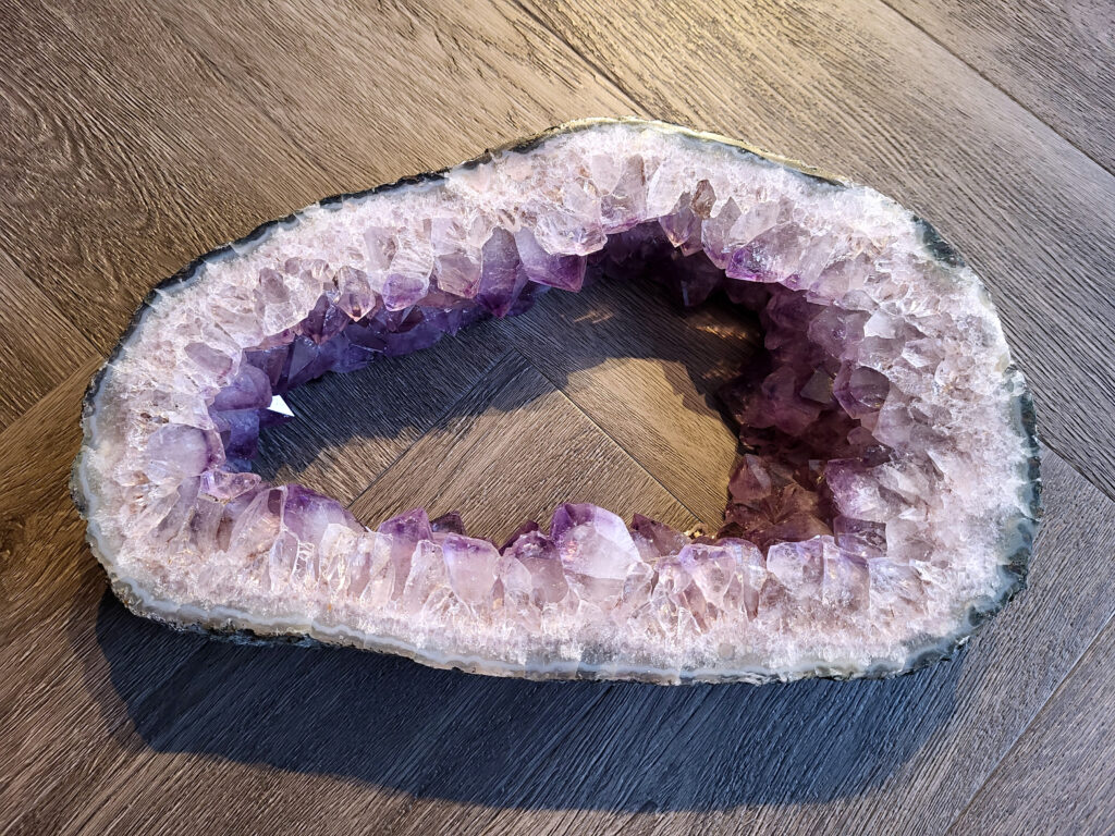 <strong>Amethist, Amethist portaal, 4,1kg, 21x34cm, 180,- euro, nr. 20</strong>

<strong>Amethist is een paarse variëteit van kwarts, bekend om zijn kalmerende en spirituele eigenschappen.</strong> De kleur varieert van licht lila tot diep violet en wordt veroorzaakt door sporen van ijzer en andere elementen. Amethist wordt al eeuwenlang gewaardeerd, zowel vanwege zijn esthetische schoonheid als zijn vermeende genezende en beschermende krachten. 
<strong>Amethist is een kwartskristal, vaak te vinden in geodes (holtes in gesteente) of als afzonderlijke kristallen. 
De kleur varieert van lichtpaars tot diep violet, soms met roze of blauwe tinten.</strong> 
De kleurintensiteit kan variëren, waarbij donkerdere amethisten vaak als kwalitatief worden beschouwd. 
Soms vertoont amethist dichroïsme, waarbij je verschillende kleuren kunt zien wanneer je de steen in het licht draait. 

<strong>Vindplaatsen:</strong>
Amethist wordt gevonden in verschillende delen van de wereld, waaronder Brazilië, Uruguay, Zambia, Madagaskar, Rusland en Canada.
Het wordt vaak gevonden in bergachtige gebieden. 

Gebruik:
<strong>Amethist wordt gebruikt in sieraden, decoratieve objecten en als helende steen. </strong>
Het wordt vaak gedragen als hanger, ring of armband, of geplaatst in ruimtes om de energie te zuiveren. 
<strong>Amethist wordt ook gebruikt in meditatie en andere spirituele praktijken.</strong>