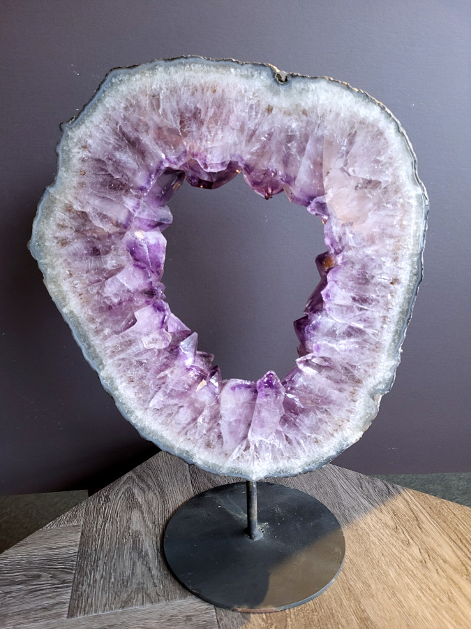 <strong>Amethist, Amethist portaal, 7,3 kg, 45 cm hoog, 328,- euro, nr. 7</strong>

<strong>Amethist is een paarse variëteit van kwarts, bekend om zijn kalmerende en spirituele eigenschappen. </strong>De kleur varieert van licht lila tot diep violet en wordt veroorzaakt door sporen van ijzer en andere elementen. Amethist wordt al eeuwenlang gewaardeerd, zowel vanwege zijn esthetische schoonheid als zijn vermeende genezende en beschermende krachten. 
<strong>Amethist is een kwartskristal, vaak te vinden in geodes (holtes in gesteente) of als afzonderlijke kristallen. 
De kleur varieert van lichtpaars tot diep violet, soms met roze of blauwe tinten. </strong>
De kleurintensiteit kan variëren, waarbij donkerdere amethisten vaak als kwalitatief worden beschouwd. 
Soms vertoont amethist dichroïsme, waarbij je verschillende kleuren kunt zien wanneer je de steen in het licht draait. 

<strong>Vindplaatsen:</strong>
Amethist wordt gevonden in verschillende delen van de wereld, waaronder Brazilië, Uruguay, Zambia, Madagaskar, Rusland en Canada.
Het wordt vaak gevonden in bergachtige gebieden. 

Gebruik:
<strong>Amethist wordt gebruikt in sieraden, decoratieve objecten en als helende steen.</strong> 
Het wordt vaak gedragen als hanger, ring of armband, of geplaatst in ruimtes om de energie te zuiveren. 
<strong>Amethist wordt ook gebruikt in meditatie en andere spirituele praktijken. </strong>