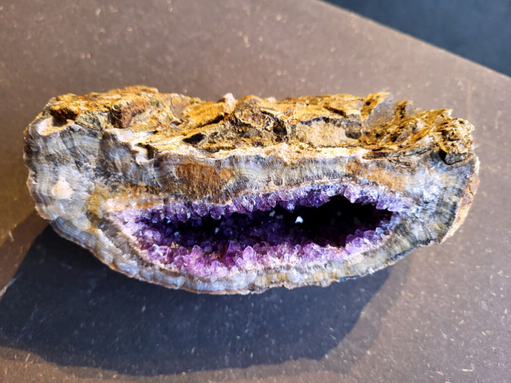 Amethist Cluster, Amethist, 1,2 kg, 31,- euro, 14

Beschrijving Amethist.
Amethist is een paarse variëteit van kwarts, bekend om zijn kalmerende en spirituele eigenschappen. De kleur varieert van licht lila tot diep violet en wordt veroorzaakt door sporen van ijzer en andere elementen. Amethist wordt al eeuwenlang gewaardeerd, zowel vanwege zijn esthetische schoonheid als zijn vermeende genezende en beschermende krachten. 
Amethist is een kwartskristal, vaak te vinden in geodes (holtes in gesteente) of als afzonderlijke kristallen. 
De kleur varieert van lichtpaars tot diep violet, soms met roze of blauwe tinten. 
De kleurintensiteit kan variëren, waarbij donkerdere amethisten vaak als kwalitatief worden beschouwd. 
Soms vertoont amethist dichroïsme, waarbij je verschillende kleuren kunt zien wanneer je de steen in het licht draait. 
Vindplaatsen:
Amethist wordt gevonden in verschillende delen van de wereld, waaronder Brazilië, Uruguay, Zambia, Madagaskar, Rusland en Canada.
Het wordt vaak gevonden in bergachtige gebieden. 

Gebruik:
Amethist wordt gebruikt in sieraden, decoratieve objecten en als helende steen. 
Het wordt vaak gedragen als hanger, ring of armband, of geplaatst in ruimtes om de energie te zuiveren. 
Amethist wordt ook gebruikt in meditatie en andere spirituele praktijken. 