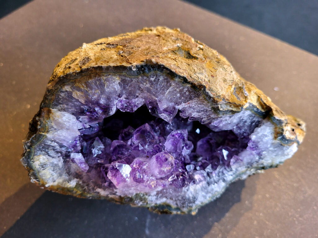 <strong>Amethist Cluster, Amethist, 3 kg, 75,- euro, nr. 1</strong>

Beschrijving Amethist.
<strong>Amethist is een paarse variëteit van kwarts, bekend om zijn kalmerende en spirituele eigenschappen.</strong> De kleur varieert van licht lila tot diep violet en wordt veroorzaakt door sporen van ijzer en andere elementen. Amethist wordt al eeuwenlang gewaardeerd, zowel vanwege zijn esthetische schoonheid als zijn vermeende genezende en beschermende krachten. 
<strong>Amethist is een kwartskristal, vaak te vinden in geodes (holtes in gesteente) of als afzonderlijke kristallen. 
De kleur varieert van lichtpaars tot diep violet, soms met roze of blauwe tinten. </strong>
De kleurintensiteit kan variëren, waarbij donkerdere amethisten vaak als kwalitatief worden beschouwd. 
Soms vertoont amethist dichroïsme, waarbij je verschillende kleuren kunt zien wanneer je de steen in het licht draait. 

<strong>Vindplaatsen:</strong>
Amethist wordt gevonden in verschillende delen van de wereld, waaronder Brazilië, Uruguay, Zambia, Madagaskar, Rusland en Canada.
Het wordt vaak gevonden in bergachtige gebieden. 

<strong>Gebruik:</strong>
Amethist wordt gebruikt in sieraden, decoratieve objecten en als helende steen. 
Het wordt vaak gedragen als hanger, ring of armband, of geplaatst in ruimtes om de energie te zuiveren. 
<strong>Amethist wordt ook gebruikt in meditatie en andere spirituele praktijken. </strong>