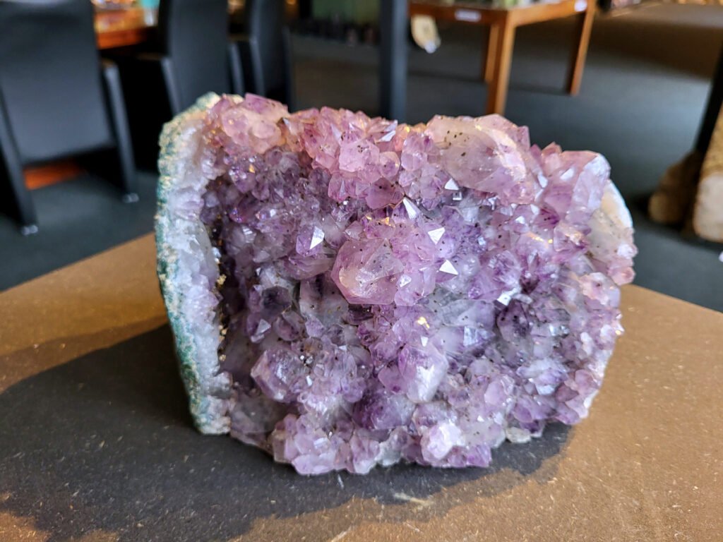 <strong>Amethist Cluster, Amethist, 4,2 kg, 65,- euro, nr. 8</strong>

Beschrijving Amethist.
<strong>Amethist is een paarse variëteit van kwarts, bekend om zijn kalmerende en spirituele eigenschappen.</strong> De kleur varieert van licht lila tot diep violet en wordt veroorzaakt door sporen van ijzer en andere elementen. Amethist wordt al eeuwenlang gewaardeerd, zowel vanwege zijn esthetische schoonheid als zijn vermeende genezende en beschermende krachten. 
<strong>Amethist is een kwartskristal, vaak te vinden in geodes (holtes in gesteente) of als afzonderlijke kristallen. 
De kleur varieert van lichtpaars tot diep violet, soms met roze of blauwe tinten.</strong> 
De kleurintensiteit kan variëren, waarbij donkerdere amethisten vaak als kwalitatief worden beschouwd. 
Soms vertoont amethist dichroïsme, waarbij je verschillende kleuren kunt zien wanneer je de steen in het licht draait. 

<strong>Vindplaatsen:</strong>
Amethist wordt gevonden in verschillende delen van de wereld, waaronder Brazilië, Uruguay, Zambia, Madagaskar, Rusland en Canada.
Het wordt vaak gevonden in bergachtige gebieden. 

<strong>Gebruik:</strong>
Amethist wordt gebruikt in sieraden, decoratieve objecten en als helende steen. 
Het wordt vaak gedragen als hanger, ring of armband, of geplaatst in ruimtes om de energie te zuiveren. 
<strong>Amethist wordt ook gebruikt in meditatie en andere spirituele praktijken. </strong>