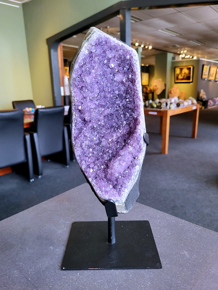 Amethist-op-standaard-Kunstgalerie-arnold-Amethist-4,3kg-130,-euro, nr. 1

Beschrijving Amethist.
Amethist is een paarse variëteit van kwarts, bekend om zijn kalmerende en spirituele eigenschappen. De kleur varieert van licht lila tot diep violet en wordt veroorzaakt door sporen van ijzer en andere elementen. Amethist wordt al eeuwenlang gewaardeerd, zowel vanwege zijn esthetische schoonheid als zijn vermeende genezende en beschermende krachten. 
Amethist is een kwartskristal, vaak te vinden in geodes (holtes in gesteente) of als afzonderlijke kristallen. 
De kleur varieert van lichtpaars tot diep violet, soms met roze of blauwe tinten. 
De kleurintensiteit kan variëren, waarbij donkerdere amethisten vaak als kwalitatief worden beschouwd. 
Soms vertoont amethist dichroïsme, waarbij je verschillende kleuren kunt zien wanneer je de steen in het licht draait. 

Vindplaatsen:
Amethist wordt gevonden in verschillende delen van de wereld, waaronder Brazilië, Uruguay, Zambia, Madagaskar, Rusland en Canada.
Het wordt vaak gevonden in bergachtige gebieden. 

Gebruik:
Amethist wordt gebruikt in sieraden, decoratieve objecten en als helende steen. 
Het wordt vaak gedragen als hanger, ring of armband, of geplaatst in ruimtes om de energie te zuiveren. 
Amethist wordt ook gebruikt in meditatie en andere spirituele praktijken. 


