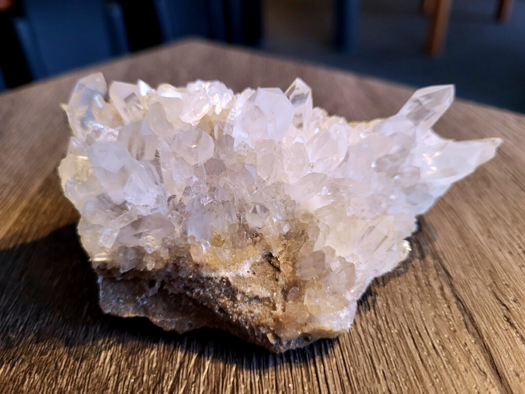 <strong>Bergkristal, 0,2 kg, 10,- euro, nr. 2</strong>

Beschrijving Bergkristal.

<strong>Bergkristal is een heldere, kleurloze variëteit van kwarts en is een van de meest voorkomende edelstenen.</strong> Het staat bekend om zijn glasachtige glans en wordt gewaardeerd om zijn zuivere, krachtige energie en wordt vaak gebruikt in sieraden, meditatie en heling. 
<strong>Eigenschappen en gebruik:</strong>
Uiterlijk:
Bergkristal is meestal kleurloos en transparant, maar kan ook melkachtig wit zijn door insluitingen van lucht of water. 
<strong>Hardheid:</strong>
Het heeft een hardheid van 7 op de schaal van Mohs, wat betekent dat het vrij duurzaam is. 
Chemische samenstelling:
Bergkristal is siliciumdioxide (SiO2). 
<strong>Gebruik:</strong>
Sieraden: Het wordt vaak verwerkt in hangers, ringen, armbanden en andere sieraden. 
Meditatie en heling: Het wordt gebruikt om energie te zuiveren, te versterken en te balanceren, en wordt vaak ingezet bij meditaties en andere spirituele praktijken. 
Technologie: Kwarts, inclusief bergkristal, wordt gebruikt in elektronica vanwege zijn piezo-elektrische eigenschappen, zoals in quartz oscillatoren. 
Decoratie: Het wordt ook gebruikt voor decoratieve doeleinden, zoals beeldjes, stenen en andere ornamenten. 
<strong>Herkomst:</strong>
Bergkristal wordt op veel plaatsen in de wereld gevonden, zoals Brazilië, Madagaskar, de Himalaya en Zwitserland. 
<strong>Spirituele betekenis:</strong>
Zuivering en balans:
Bergkristal wordt vaak gezien als een steen die energieën zuivert en in balans brengt, zowel fysiek als energetisch. 
<strong>Heldere geest:</strong>
Het zou helderheid van geest bevorderen en helpen bij het loslaten van negatieve gedachten en emoties. 
Versterking van energie:
Bergkristal wordt vaak gebruikt om de energie van andere stenen te versterken. 
<strong>Bescherming:</strong>
In sommige culturen wordt bergkristal gezien als een beschermende steen die aura's beschermt tegen negatieve invloeden.