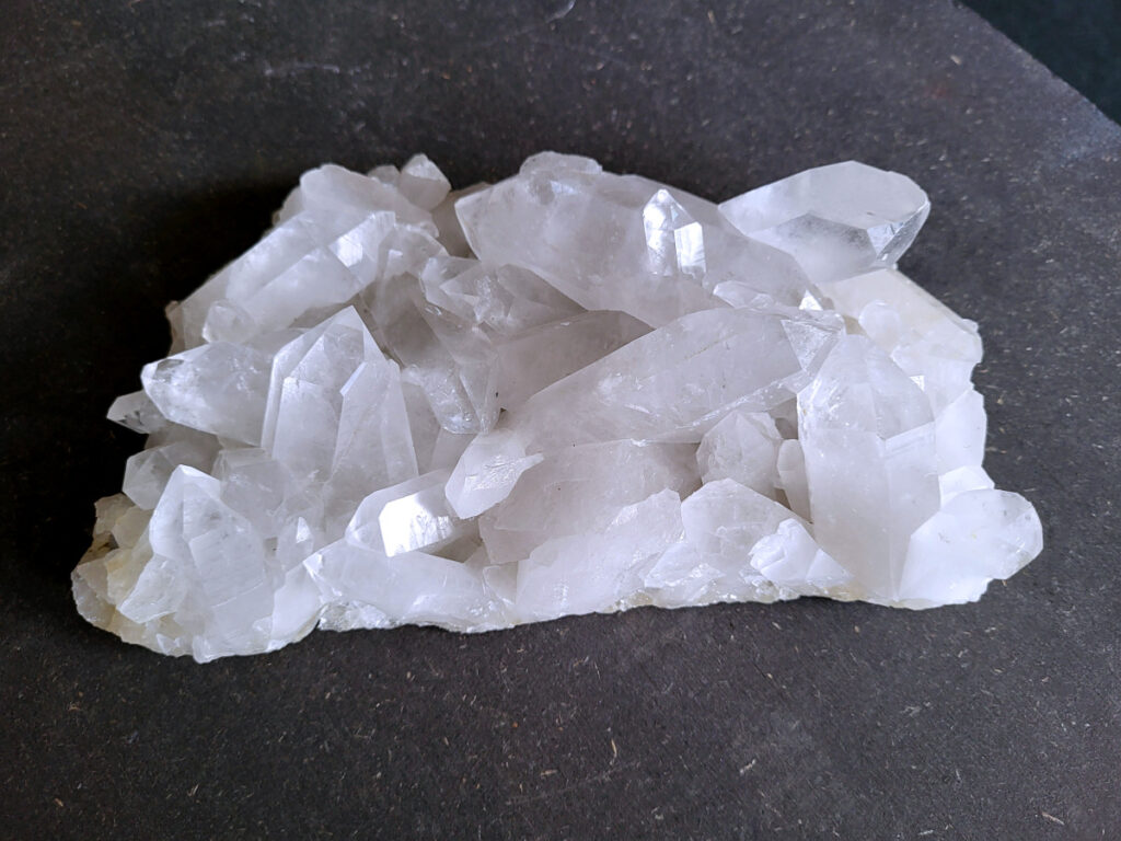 Bergkristal, Bergkristal geode, Bergkristal cluster, 1,3kg, 50,- euro, nr. 22

Beschrijving Bergkristal.

Bergkristal is een heldere, kleurloze variëteit van kwarts en is een van de meest voorkomende edelstenen. Het staat bekend om zijn glasachtige glans en wordt gewaardeerd om zijn zuivere, krachtige energie en wordt vaak gebruikt in sieraden, meditatie en heling. 
Eigenschappen en gebruik:
Uiterlijk:
Bergkristal is meestal kleurloos en transparant, maar kan ook melkachtig wit zijn door insluitingen van lucht of water. 
Hardheid:
Het heeft een hardheid van 7 op de schaal van Mohs, wat betekent dat het vrij duurzaam is. 
Chemische samenstelling:
Bergkristal is siliciumdioxide (SiO2). 
Gebruik:
Sieraden: Het wordt vaak verwerkt in hangers, ringen, armbanden en andere sieraden. 
Meditatie en heling: Het wordt gebruikt om energie te zuiveren, te versterken en te balanceren, en wordt vaak ingezet bij meditaties en andere spirituele praktijken. 
Technologie: Kwarts, inclusief bergkristal, wordt gebruikt in elektronica vanwege zijn piezo-elektrische eigenschappen, zoals in quartz oscillatoren. 
Decoratie: Het wordt ook gebruikt voor decoratieve doeleinden, zoals beeldjes, stenen en andere ornamenten. 
Herkomst:
Bergkristal wordt op veel plaatsen in de wereld gevonden, zoals Brazilië, Madagaskar, de Himalaya en Zwitserland. 
Spirituele betekenis:
Zuivering en balans:
Bergkristal wordt vaak gezien als een steen die energieën zuivert en in balans brengt, zowel fysiek als energetisch. 
Heldere geest:
Het zou helderheid van geest bevorderen en helpen bij het loslaten van negatieve gedachten en emoties. 
Versterking van energie:
Bergkristal wordt vaak gebruikt om de energie van andere stenen te versterken. 
Bescherming:
In sommige culturen wordt bergkristal gezien als een beschermende steen die aura's beschermt tegen negatieve invloeden. 