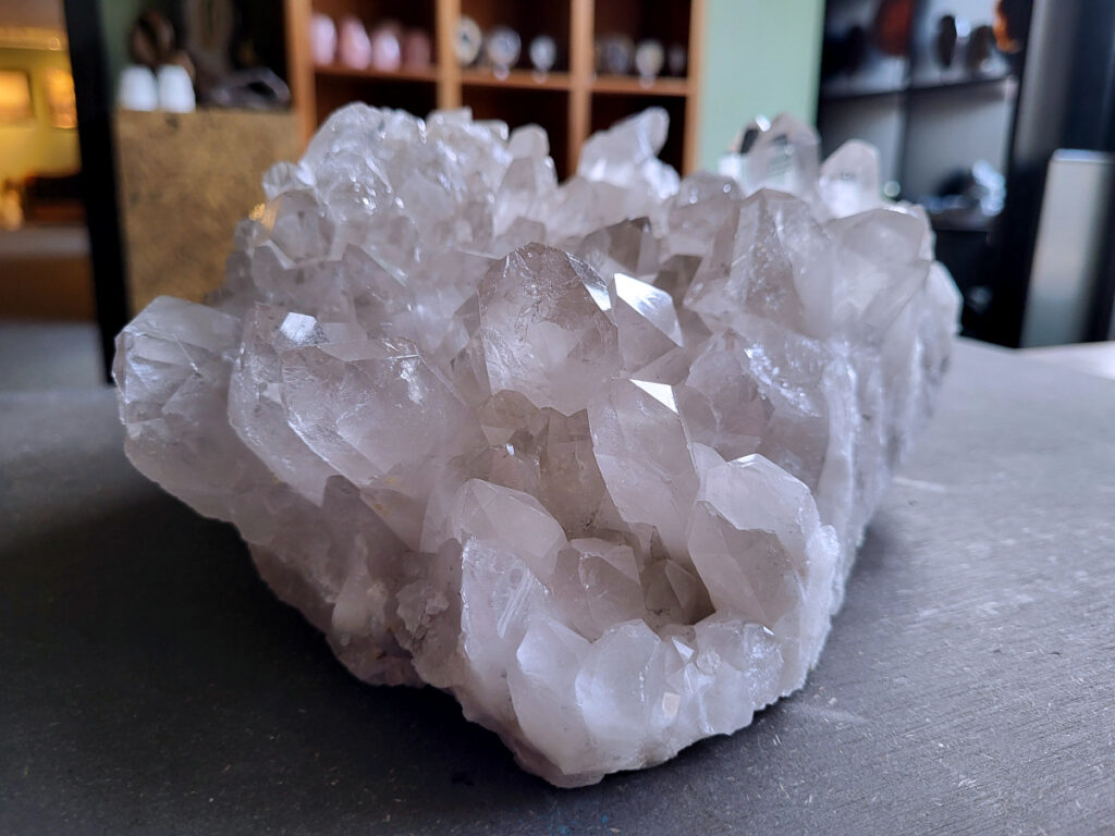 Bergkristal, Bergkristal geode, Bergkristal cluster, 6,1kg, 275,- euro, nr. 23

Beschrijving Bergkristal.

Bergkristal is een heldere, kleurloze variëteit van kwarts en is een van de meest voorkomende edelstenen. Het staat bekend om zijn glasachtige glans en wordt gewaardeerd om zijn zuivere, krachtige energie en wordt vaak gebruikt in sieraden, meditatie en heling. 
Eigenschappen en gebruik:
Uiterlijk:
Bergkristal is meestal kleurloos en transparant, maar kan ook melkachtig wit zijn door insluitingen van lucht of water. 
Hardheid:
Het heeft een hardheid van 7 op de schaal van Mohs, wat betekent dat het vrij duurzaam is. 
Chemische samenstelling:
Bergkristal is siliciumdioxide (SiO2). 
Gebruik:
Sieraden: Het wordt vaak verwerkt in hangers, ringen, armbanden en andere sieraden. 
Meditatie en heling: Het wordt gebruikt om energie te zuiveren, te versterken en te balanceren, en wordt vaak ingezet bij meditaties en andere spirituele praktijken. 
Technologie: Kwarts, inclusief bergkristal, wordt gebruikt in elektronica vanwege zijn piezo-elektrische eigenschappen, zoals in quartz oscillatoren. 
Decoratie: Het wordt ook gebruikt voor decoratieve doeleinden, zoals beeldjes, stenen en andere ornamenten. 
Herkomst:
Bergkristal wordt op veel plaatsen in de wereld gevonden, zoals Brazilië, Madagaskar, de Himalaya en Zwitserland. 
Spirituele betekenis:
Zuivering en balans:
Bergkristal wordt vaak gezien als een steen die energieën zuivert en in balans brengt, zowel fysiek als energetisch. 
Heldere geest:
Het zou helderheid van geest bevorderen en helpen bij het loslaten van negatieve gedachten en emoties. 
Versterking van energie:
Bergkristal wordt vaak gebruikt om de energie van andere stenen te versterken. 
Bescherming:
In sommige culturen wordt bergkristal gezien als een beschermende steen die aura's beschermt tegen negatieve invloeden. 
