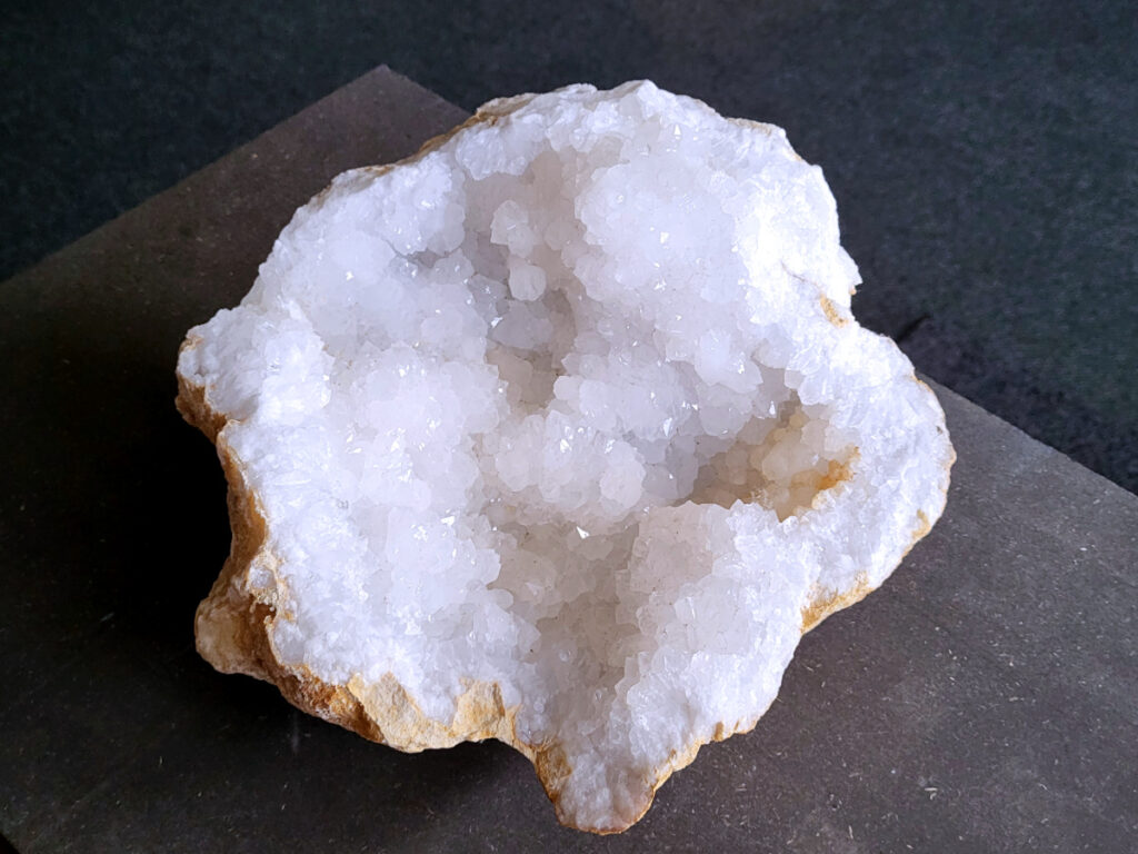 Bergkristal, Bergkristal geode, Bergkristal cluster, 6,1kg, 61,- euro, nr. 24

Beschrijving Bergkristal.

Bergkristal is een heldere, kleurloze variëteit van kwarts en is een van de meest voorkomende edelstenen. Het staat bekend om zijn glasachtige glans en wordt gewaardeerd om zijn zuivere, krachtige energie en wordt vaak gebruikt in sieraden, meditatie en heling. 
Eigenschappen en gebruik:
Uiterlijk:
Bergkristal is meestal kleurloos en transparant, maar kan ook melkachtig wit zijn door insluitingen van lucht of water. 
Hardheid:
Het heeft een hardheid van 7 op de schaal van Mohs, wat betekent dat het vrij duurzaam is. 
Chemische samenstelling:
Bergkristal is siliciumdioxide (SiO2). 
Gebruik:
Sieraden: Het wordt vaak verwerkt in hangers, ringen, armbanden en andere sieraden. 
Meditatie en heling: Het wordt gebruikt om energie te zuiveren, te versterken en te balanceren, en wordt vaak ingezet bij meditaties en andere spirituele praktijken. 
Technologie: Kwarts, inclusief bergkristal, wordt gebruikt in elektronica vanwege zijn piezo-elektrische eigenschappen, zoals in quartz oscillatoren. 
Decoratie: Het wordt ook gebruikt voor decoratieve doeleinden, zoals beeldjes, stenen en andere ornamenten. 
Herkomst:
Bergkristal wordt op veel plaatsen in de wereld gevonden, zoals Brazilië, Madagaskar, de Himalaya en Zwitserland. 
Spirituele betekenis:
Zuivering en balans:
Bergkristal wordt vaak gezien als een steen die energieën zuivert en in balans brengt, zowel fysiek als energetisch. 
Heldere geest:
Het zou helderheid van geest bevorderen en helpen bij het loslaten van negatieve gedachten en emoties. 
Versterking van energie:
Bergkristal wordt vaak gebruikt om de energie van andere stenen te versterken. 
Bescherming:
In sommige culturen wordt bergkristal gezien als een beschermende steen die aura's beschermt tegen negatieve invloeden. 