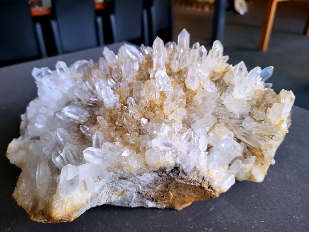 Bergkristal, kristal topstuk, cluster, helder, 3,6 kg, 108,- euro, scherpe prijs, nr. 22

Beschrijving Bergkristal.

Bergkristal is een heldere, kleurloze variëteit van kwarts en is een van de meest voorkomende edelstenen. Het staat bekend om zijn glasachtige glans en wordt gewaardeerd om zijn zuivere, krachtige energie en wordt vaak gebruikt in sieraden, meditatie en heling. 
Eigenschappen en gebruik:
Uiterlijk:
Bergkristal is meestal kleurloos en transparant, maar kan ook melkachtig wit zijn door insluitingen van lucht of water. 
Hardheid:
Het heeft een hardheid van 7 op de schaal van Mohs, wat betekent dat het vrij duurzaam is. 
Chemische samenstelling:
Bergkristal is siliciumdioxide (SiO2). 
Gebruik:
Sieraden: Het wordt vaak verwerkt in hangers, ringen, armbanden en andere sieraden. 
Meditatie en heling: Het wordt gebruikt om energie te zuiveren, te versterken en te balanceren, en wordt vaak ingezet bij meditaties en andere spirituele praktijken. 
Technologie: Kwarts, inclusief bergkristal, wordt gebruikt in elektronica vanwege zijn piezo-elektrische eigenschappen, zoals in quartz oscillatoren. 
Decoratie: Het wordt ook gebruikt voor decoratieve doeleinden, zoals beeldjes, stenen en andere ornamenten. 
Herkomst:
Bergkristal wordt op veel plaatsen in de wereld gevonden, zoals Brazilië, Madagaskar, de Himalaya en Zwitserland. 
Spirituele betekenis:
Zuivering en balans:
Bergkristal wordt vaak gezien als een steen die energieën zuivert en in balans brengt, zowel fysiek als energetisch. 
Heldere geest:
Het zou helderheid van geest bevorderen en helpen bij het loslaten van negatieve gedachten en emoties. 
Versterking van energie:
Bergkristal wordt vaak gebruikt om de energie van andere stenen te versterken. 
Bescherming:
In sommige culturen wordt bergkristal gezien als een beschermende steen die aura's beschermt tegen negatieve invloeden. 