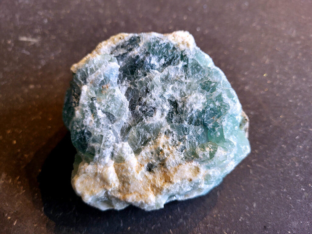 <strong>Fluoriet, brok groene fluoriet, 0,5 kg, 14,- euro</strong>

Fluoriet,
<strong>Fluoriet is een veelzijdig, kleurrijk mineraal (calciumfluoride) dat bekend staat om zijn sterke concentratie bevorderende, beschermende en reinigende werking op de geest. </strong>Het ordent chaos, helpt bij studie en emotionele stabiliteit, en wordt vaak gebruikt om elektromagnetische straling te verminderen. Het mineraal fluoresceert vaak onder UV-licht.
<strong>Kernmerken van Fluoriet:</strong>
<strong>Kleur:</strong> Zeer variabel, inclusief paars, groen, blauw, geel en kleurloos.
<strong>Hardheid: </strong>4 op de schaal van Mohs (tamelijk zacht).
<strong>Kristalstelsel:</strong> Kubisch, vaak als octaëder.
<strong>Toepassing:</strong> Geliefd bij verzamelaars, spirituele beoefenaars (meditatie) en industrieel gebruikt als vloeispaat (vloeimiddel bij metaalsmelting).
<strong>Spirituele en Emotionele Werking:</strong>
<strong>Focus & Studie:</strong> Helpt bij het ordenen van gedachten, concentratie en snelle informatieverwerking.
<strong>Bescherming:</strong> Werkt stabiliserend, vergroot het zelfvertrouwen en helpt tegen negatieve invloeden of overprikkeling.
<strong>Emotionele balans:</strong> Brengt emoties in evenwicht en helpt bij het loslaten van oude patronen. 
<strong>Fysieke Werking (Edelsteentherapie):</strong>
<strong>Botten en Gebit:</strong> Ondersteunt de gezondheid van tanden, botten en gewrichten.
<strong>Pijnbestrijding:</strong> Wordt ingezet bij zenuwpijn, gordelroos en artritis.
<strong>Reiniging:</strong> Zou helpen bij ontgifting en het immuunsysteem versterken. 

<strong>Kleurvariaties en Specifieke Werking:</strong>
<strong>Groene Fluoriet: </strong>Reinigt de aura, bevordert emotionele healing en nuchterheid.
<strong>Paarse Fluoriet:</strong> Stimuleert de intuïtie en spirituele wijsheid.
<strong>Blauwe Fluoriet:</strong> Ondersteunt communicatie en creativiteit.
<strong>Regenboogfluoriet:</strong> Combineert de eigenschappen van de verschillende kleuren.