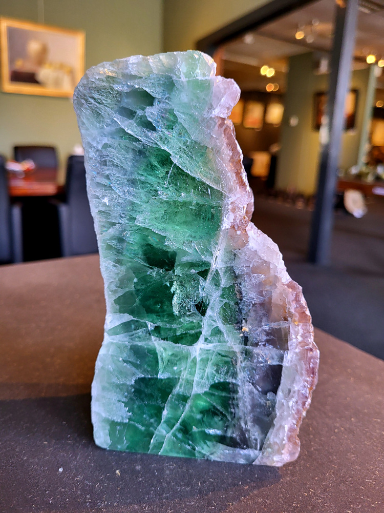 <strong>Fluoriet, brok fluoriet groen/paars gedeeltelijk gepolijst, 2 kg, 73,- euro, nr. 5</strong>

Fluoriet,
<strong>Fluoriet is een veelzijdig, kleurrijk mineraal (calciumfluoride) dat bekend staat om zijn sterke concentratie bevorderende, beschermende en reinigende werking op de geest.</strong> Het ordent chaos, helpt bij studie en emotionele stabiliteit, en wordt vaak gebruikt om elektromagnetische straling te verminderen. Het mineraal fluoresceert vaak onder UV-licht.
<strong>Kernmerken van Fluoriet:</strong>
Kleur: Zeer variabel, inclusief paars, groen, blauw, geel en kleurloos.
Hardheid: 4 op de schaal van Mohs (tamelijk zacht).
Kristalstelsel: Kubisch, vaak als octaëder.
Toepassing: Geliefd bij verzamelaars, spirituele beoefenaars (meditatie) en industrieel gebruikt als vloeispaat (vloeimiddel bij metaalsmelting).
<strong>Spirituele en Emotionele Werking:</strong>
Focus & Studie: Helpt bij het ordenen van gedachten, concentratie en snelle informatieverwerking.
Bescherming: Werkt stabiliserend, vergroot het zelfvertrouwen en helpt tegen negatieve invloeden of overprikkeling.
Emotionele balans: Brengt emoties in evenwicht en helpt bij het loslaten van oude patronen. 
Fysieke Werking (Edelsteentherapie):
Botten en Gebit: Ondersteunt de gezondheid van tanden, botten en gewrichten.
Pijnbestrijding: Wordt ingezet bij zenuwpijn, gordelroos en artritis.
Reiniging: Zou helpen bij ontgifting en het immuunsysteem versterken. 

<strong>Kleurvariaties en Specifieke Werking:
Groene Fluoriet: Reinigt de aura, bevordert emotionele healing en nuchterheid.
Paarse Fluoriet: Stimuleert de intuïtie en spirituele wijsheid.
Blauwe Fluoriet: Ondersteunt communicatie en creativiteit.
Regenboogfluoriet: Combineert de eigenschappen van de verschillende kleuren. 
</strong>