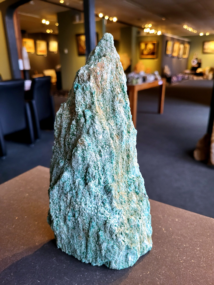 <strong>Fuchsiet, 2,2 kg, 23cm hoog, 32,- euro, nr. 2</strong>

Beschrijving, Fuchsiet.

<strong>Fuchsiet is een groene, chroomhoudende variant van muscoviet, een soort mica. Het dankt zijn kleur aan de aanwezigheid van chroom en wordt vaak gevonden in metamorf gesteente zoals gneis en schist, maar ook in stollingsgesteente zoals graniet.</strong> Fuchsiet wordt beschouwd als een steen die inzicht, zelfbeschikking en bescherming bevordert. 
<strong>Eigenschappen en werking:</strong>
<strong>Inzicht en zelfbeschikking:</strong>
Fuchsiet helpt bij het verkrijgen van inzicht in relaties en bevordert een gezonde interactie met anderen, zonder wederzijdse afhankelijkheid. 
<strong>Bescherming:</strong>
De steen beschermt tegen negatieve energieën en emoties van anderen en helpt je om je grenzen duidelijker te stellen. 
<strong>Emotionele balans:</strong>
Fuchsiet kan helpen bij het loslaten van negatieve emoties en het overwinnen van een slachtofferrol. 
<strong>Fysieke ondersteuning:</strong>
Sommige bronnen beweren dat fuchsiet ondersteunend kan werken bij allergieën, jeuk, ontstekingen, bloed- en zenuwklachten. 
<strong>Combinaties:</strong>
Fuchsiet wordt vaak gevonden met robijn, waarbij de combinatie krachtige energie, moed en doorzettingsvermogen kan versterken. 
<strong>Chakra:</strong>
Fuchsiet wordt geassocieerd met het hartchakra (4e chakra). 
<strong>Verzorging:</strong>
Fuchsiet kan beter niet met water gereinigd worden, aldus Edelstenen en Mineralen. 
Andere bronnen suggereren dat het reinigen onder stromend water of een nacht in zout water een optie is. 
<strong>Vindplaatsen:
Brazilië is een bekende vindplaats van fuchsiet. </strong>