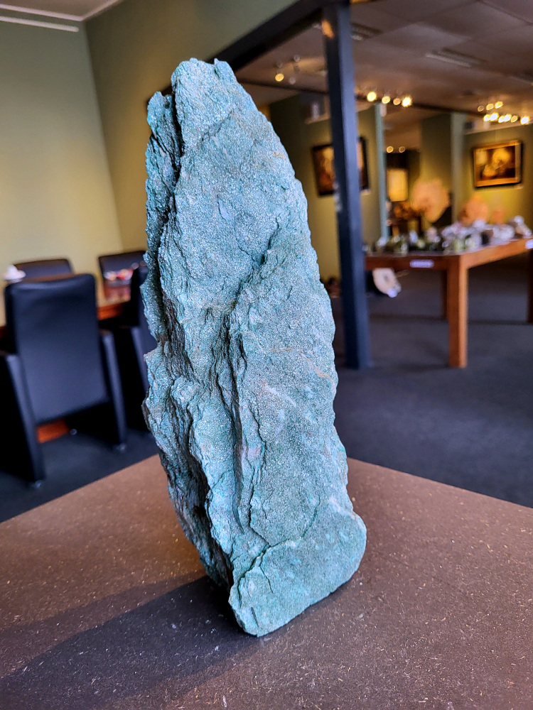 <strong>Fuchsiet, 2,5 kg, 28cm hoog, 38,- euro, nr. 3</strong>

Beschrijving, Fuchsiet.

<strong>Fuchsiet is een groene, chroomhoudende variant van muscoviet, een soort mica. Het dankt zijn kleur aan de aanwezigheid van chroom en wordt vaak gevonden in metamorf gesteente zoals gneis en schist, maar ook in stollingsgesteente zoals graniet.</strong> Fuchsiet wordt beschouwd als een steen die inzicht, zelfbeschikking en bescherming bevordert. 
<strong>Eigenschappen en werking:</strong>
<strong>Inzicht en zelfbeschikking:</strong>
Fuchsiet helpt bij het verkrijgen van inzicht in relaties en bevordert een gezonde interactie met anderen, zonder wederzijdse afhankelijkheid. 
<strong>Bescherming:</strong>
De steen beschermt tegen negatieve energieën en emoties van anderen en helpt je om je grenzen duidelijker te stellen. 
<strong>Emotionele balans:</strong>
Fuchsiet kan helpen bij het loslaten van negatieve emoties en het overwinnen van een slachtofferrol. 
<strong>Fysieke ondersteuning:</strong>
Sommige bronnen beweren dat fuchsiet ondersteunend kan werken bij allergieën, jeuk, ontstekingen, bloed- en zenuwklachten. 
<strong>Combinaties:</strong>
Fuchsiet wordt vaak gevonden met robijn, waarbij de combinatie krachtige energie, moed en doorzettingsvermogen kan versterken. 
<strong>Chakra:</strong>
Fuchsiet wordt geassocieerd met het hartchakra (4e chakra). 
<strong>Verzorging:</strong>
Fuchsiet kan beter niet met water gereinigd worden, aldus Edelstenen en Mineralen. 
Andere bronnen suggereren dat het reinigen onder stromend water of een nacht in zout water een optie is. 
<strong>Vindplaatsen:
Brazilië is een bekende vindplaats van fuchsiet. </strong>