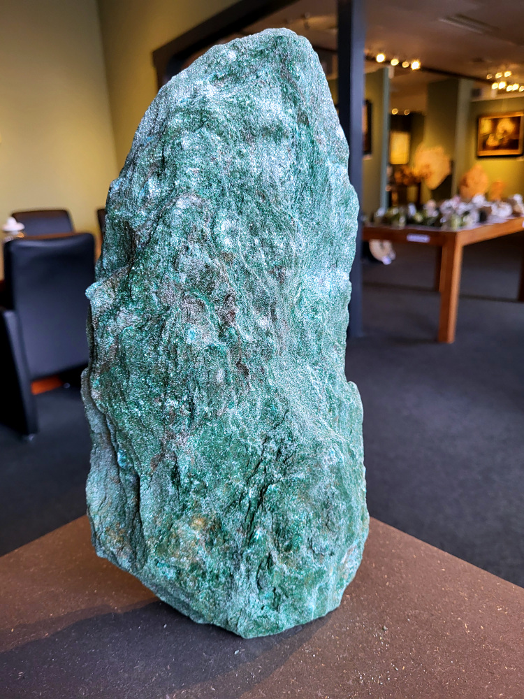 <strong>Fuchsiet, 5,5 kg, 35cm hoog, 85,- euro, nr. 6</strong>

Beschrijving, Fuchsiet.

<strong>Fuchsiet is een groene, chroomhoudende variant van muscoviet, een soort mica. Het dankt zijn kleur aan de aanwezigheid van chroom en wordt vaak gevonden in metamorf gesteente zoals gneis en schist, maar ook in stollingsgesteente zoals graniet.</strong> Fuchsiet wordt beschouwd als een steen die inzicht, zelfbeschikking en bescherming bevordert. 
<strong>Eigenschappen en werking:
Inzicht en zelfbeschikking:</strong>
Fuchsiet helpt bij het verkrijgen van inzicht in relaties en bevordert een gezonde interactie met anderen, zonder wederzijdse afhankelijkheid. 
<strong>Bescherming:</strong>
De steen beschermt tegen negatieve energieën en emoties van anderen en helpt je om je grenzen duidelijker te stellen. 
<strong>Emotionele balans:</strong>
Fuchsiet kan helpen bij het loslaten van negatieve emoties en het overwinnen van een slachtofferrol. 
<strong>Fysieke ondersteuning:</strong>
Sommige bronnen beweren dat fuchsiet ondersteunend kan werken bij allergieën, jeuk, ontstekingen, bloed- en zenuwklachten. 
<strong>Combinaties:</strong>
Fuchsiet wordt vaak gevonden met robijn, waarbij de combinatie krachtige energie, moed en doorzettingsvermogen kan versterken. 
<strong>Chakra:</strong>
Fuchsiet wordt geassocieerd met het hartchakra (4e chakra). 
<strong>Verzorging:</strong>
Fuchsiet kan beter niet met water gereinigd worden, aldus Edelstenen en Mineralen. 
Andere bronnen suggereren dat het reinigen onder stromend water of een nacht in zout water een optie is. 
<strong>Vindplaatsen:
Brazilië is een bekende vindplaats van fuchsiet. 
</strong>