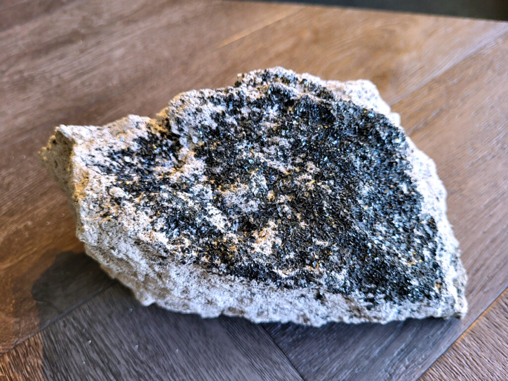 <strong>Kwarts, Druzy Kwarts, 1,4 kg, 14,- euro, nr. 1</strong>

Kwarts, Druzy Kwarts op een matrix van Calciet

<strong>Druzy kwarts op een matrix van calciet (waarschijnlijk ijzer/mangaan-oxiden).</strong>
De donkere kleine kwartskristalletjes (druzy) glinsteren je tegemoet.
De ondergrond is wit/grijs en dat is typisch voor calciet 
De donkere kleur komt vaak door mineralen zoals hematiet of mangaan die tijdens de vorming in de kwarts zijn gekomen.
<strong>Druzy kwarts op calciet met donkere mineralisatie.</strong>

<strong>Met een sterke glitter. Dat is typisch druzy.</strong>
<strong>Spiritueel :</strong>
<strong>Druzy kwarts wordt vaak gezien als versterker van energie en helderheid.
Door de donkere mineralen wordt hij soms gezien als beschermend / aardend.
Zulke natuurlijke stukken komen vaak uit Marokko of China.</strong>