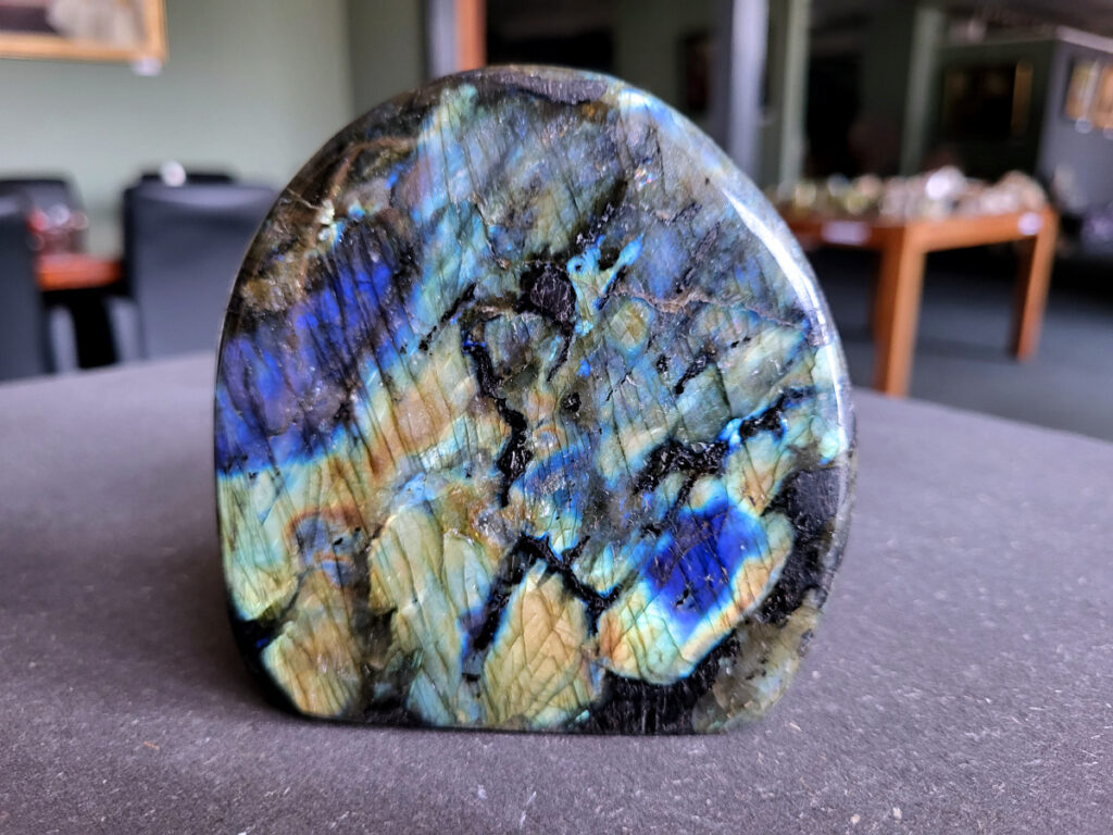 Labradoriet, top labradoriet, 0,9 kg, 30,- euro, nr. 2

Beschrijving, Labradoriet.
Labradoriet is een edelsteen die bekend staat om zijn iriserende kleurenspel, ook wel labradoriseren genoemd, dat vaak doet denken aan het noorderlicht. Het is een populaire steen in de edelstenenwereld vanwege zowel zijn uiterlijk als zijn vermeende spirituele eigenschappen. 
Wat is labradoriet?
Labradoriet is een veldspaatmineraal dat wordt gekenmerkt door een opaalachtig glans of iriserend effect, veroorzaakt door de lichtbreking in de interne structuur van de steen.
De meest voorkomende kleur is grijs of groenachtig grijs, maar de steen kan ook blauwe, gele, oranje, paarse of zelfs rode flitsen laten zien.
De steen is genoemd naar het Canadese schiereiland Labrador, waar het voor het eerst werd ontdekt. 
Spirituele betekenis en eigenschappen:
Labradoriet wordt vaak beschouwd als een beschermende steen, vooral voor mensen die gevoelig zijn voor de energieën van hun omgeving. 
Het zou helpen bij het versterken van de aura en het verminderen van energielekkage, waardoor je je weerbaarder voelt. 
Labradoriet wordt geassocieerd met het versterken van intuïtie, het vergroten van het bewustzijn en het transformeren van negatieve energieën. 
Het wordt ook gebruikt om blokkades op te heffen en de innerlijke wijsheid te onthullen. 
Gebruik:
Labradoriet wordt vaak verwerkt in sieraden zoals hangers, armbanden en oorbellen. 
Het kan ook als ruwe steen, knuffelsteen of in andere vormen worden gebruikt, bijvoorbeeld in een huis of op een werkplek. 
Labradoriet kan worden gereinigd door het onder stromend water te houden of door het te reinigen met een andere steen zoals bergkristal of seleniet. 
Vindplaatsen:
Labradoriet wordt gevonden op verschillende locaties over de hele wereld, waaronder Canada, Finland, Madagaskar en Rusland. 
                                -Kunstgalerie Arnold-