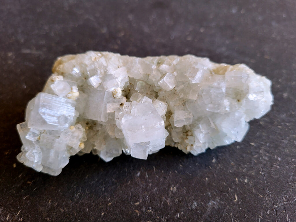 Apofyliet, doorsnee 11 cm, 180 gr. 9,- euro, nr. 3

Apofyliet op matrix, beschrijving

apofyliet op matrix
De doorzichtige tot melkachtige blokvormige kristallen zijn typisch voor apofyliet.
Apofyliet vormt vaak vierkante of rechthoekige kristallen met vlakke toppen.
De groenige korrelige ondergrond is een zeolietmatrix (bijvoorbeeld stilbiet of heulandiet).
Dit soort combinaties komt vaak uit India (Maharashtra regio).
Kenmerken van apofyliet
Kleur: transparant, wit, soms lichtgroen
Kristalvorm: kubusachtig / blokvormig met glanzende vlakken
Glans: glasachtig
Vaak gevonden samen met: stilbiet, heulandiet, calciet
Apofyliet is een helder of wit mineraal dat behoort tot de groep van de calciumsilicaten. Het wordt voornamelijk gevonden in vulkanische gesteenten, vooral in de buurt van breuken en scheuren. In de spirituele wereld wordt Apofyliet beschouwd als een krachtige steen met een hoge vibratie die helpt bij het openen en activeren van de hogere chakra's, met name het derde oog en de kruinchakra.
Apofyliet werkt ondersteunend bij innerlijke druk en angsten, tevens goede steen om fixaties en rigiditeit los te laten. De steen spoort je aan om je thuis te voelen in je eigen lichaam. Dit maakt het een zeer goede steen voor meditatieve doeleinden. De energie van Apofyliet wordt ook geassocieerd met helderheid, zuiverheid en zuivering. Het kan worden gebruikt om negatieve energieën en emoties te verwijderen en om een gevoel van kalmte en vrede te bevorderen. Het kan ook helpen bij het verminderen van stress en angst en het bevorderen van innerlijke rust en harmonie.
Fysiek wordt Apofyliet geassocieerd met het versterken van het immuunsysteem en het bevorderen van een gezonde spijsvertering. Het kan ook worden gebruikt om hoofdpijn, migraine en andere pijnlijke aandoeningen te verlichten. Het loslaten van fixaties en rigiditeit kan ook verlichting bieden voor fysieke spanning in het lichaam.
Over het algemeen wordt Apofyliet beschouwd als een krachtige steen voor spirituele groei en genezing, en het kan een waardevolle aanvulling zijn op meditatie- en genezingspraktijken. Het biedt emotionele en mentale ondersteuning door het helpen loslaten van fixaties en rigiditeit, en het bevorderen van innerlijke rust en harmonie. Het biedt ook fysieke voordelen, zoals het versterken van het immuunsysteem en het verlichten van hoofdpijn en andere pijnlijke aandoeningen.



