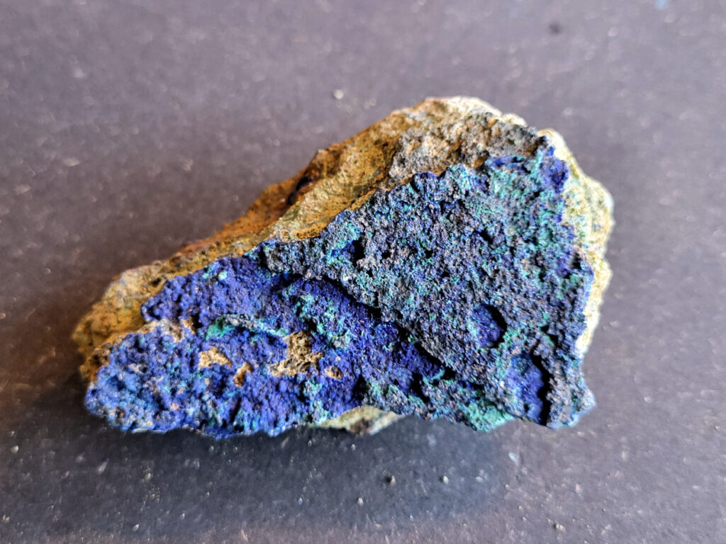 <strong>Azuriet met Malachiet, 198 gram, 6cm hoog, 9cm breed, 15,- euro, nr. 8

Azuriet op Malachiet
Azuriet op Malachiet op een ijzerrijke steen.
Azuriet heeft een diep blauwe kleur en wordt vaak gevonden in deze combinatie.
De groene stukjes zijn malachiet, een mineraal dat ontstaat waar koper in de grond zit. De bruine steen eromheen is waarschijnlijk roestachtig gesteente met ijzer.
Malachiet kan soms fel groen en korrelig groeien in kleine plekjes of holtes.
Bruine steen met groene malachiet (kopermineraal) en Azuriet.
</strong>