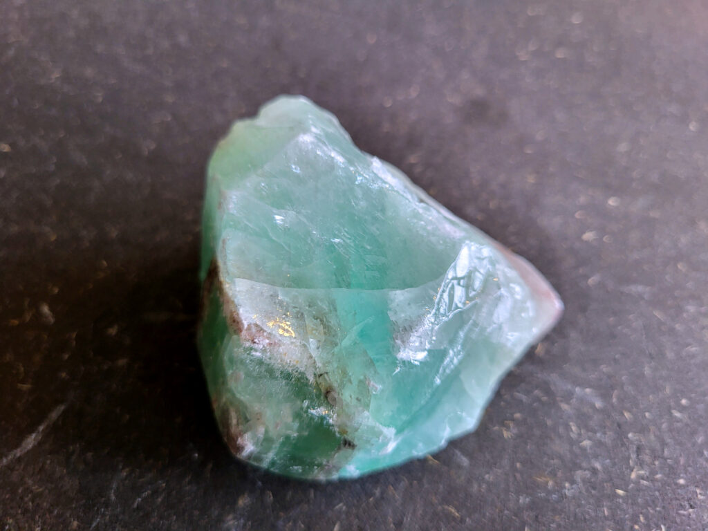 Groene Calciet, 260 gram, 6,50 euro, nr. 3

Calciet, 
Calciet is een veelvoorkomend mineraal dat voornamelijk bestaat uit calciumcarbonaat. Het komt in diverse kleuren en vormen voor en wordt in veel industrieën gebruikt, maar ook in de esoterie.
Algemene kenmerken:
Samenstelling: Calciet bestaat voornamelijk uit calciumcarbonaat (CaCO3).
Vorming: Het ontstaat door afzetting van calciumcarbonaat in water, maar ook door ophoping van schelpen en skeletten van zeedieren.
Uiterlijk: Het heeft vaak een glasachtige glans, is doorzichtig tot doorschijnend en kan vele kleuren hebben, zoals geel, oranje, rood, bruin, blauw, groen, roze, wit en kleurloos.
Hardheid: Calciet heeft een hardheid van 3 op de schaal van Mohs.
Veelvoorkomend: Het is een van de meest voorkomende mineralen en is een hoofdbestanddeel van kalksteen, marmer en krijt.
Esoterie:
In de edelsteentherapie wordt calciet gezien als een steen die energie versterkt, negatieve energieën verwijdert en spirituele groei bevordert. Verschillende kleuren calciet hebben specifieke eigenschappen, zoals gele calciet voor doorzettingsvermogen en moed, en mangano calciet voor emotionele heling.
Specifieke calcietsoorten:
Gele Calciet: Staat bekend om het absorberen van negativiteit, het versterken van doorzettingsvermogen en het aantrekken van succes.
Blauwe Calciet: Wordt geassocieerd met kalmering, communicatie en het loslaten van stress.
Groene Calciet: Werkt op de hartchakra, bevordert liefde, compassie en emotionele heling.
Mangano Calciet: Wordt gebruikt voor emotionele heling, het loslaten van oud verdriet en het versterken van zelfvertrouwen.
Reiniging:
Calciet kan op verschillende manieren gereinigd worden, maar het is belangrijk om te weten dat sommige soorten, zoals gele calciet, niet goed tegen water kunnen.
Andere reinigingsmethoden zijn bijvoorbeeld reinigen met edelstenenspray, op een Amethist of bergkristal leggen, of reinigen met selenite.
Het is een steen die kan worden gebruikt voor energieversterking, emotionele heling en het bevorderen van spirituele groei, afhankelijk van de specifieke kleur en eigenschappen.