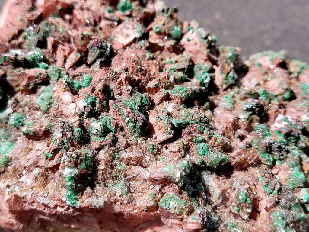 <strong>Malachiet op Dolemiet, 0,6kg, 15x7cm, 30,- euro, detailfoto, nr 3

Malachiet op Dolomiet, beschrijving,

Dit kleurrijke exemplaar bevat blauwgroene rosasiet- en groene malachietkristallenaggregaties, bovenop een laag van donkerroodbruine ferroan dolomiet. Doorschijnende selenietkristallen zijn te vinden over de hele dolomiet, evenals die de rosasiet- en malachietkristalformaties omhullen.
Rosasiet is een secundair mineraal dat zich vormt in oxidatiezones van koper-zink afzettingen, waarbij doorgaans een vezelige botryoïdale bol ontstaat die glasachtig en zijdeachtig kan lijken. Hoewel ze doorgaans een blauwgroene kleur hebben, zijn kleurloze exemplaren niet ongehoord. De chemische formule van rosasiet is CuZnCO3(OH)2.

Over Malachiet:
Malachiet is een intens groen koperachtig mineraal dat in een grote verscheidenheid aan vormen voorkomt. Malachiet kan groeien in botryoïdale massa's, stalactietische formaties en reniforme formaties, meestal als een dichte cluster van waaierende vezelige naalden die een ogenschijnlijk vaste massa vormen. Naarmate lagen zich blijven opstapelen tijdens de vorming, kunnen soms gestreepte patronen vorm krijgen, wat de ringen in alle tinten groen verklaart die bij de meeste gepolijste malachietexemplaren te zien zijn.

Malachiet ontstaat door verwering van andere koperertsen en wordt zeer vaak gevonden in verband met andere koperhoudende mineralen zoals azuriet en chrysocolla. Het is te vinden in koperafzettingen over de hele wereld, maar de Democratische Republiek Congo is de belangrijkste bron voor gepolijste malachiet- en mineraalmonsters.

Malachiet wordt al sinds de oudheid gewaardeerd, eerst als utilitair kopererts en daarna als siersteen. Vanwege zijn waarde als decoratieve steen wordt het zelden nog als kopererts gewonnen.
</strong>