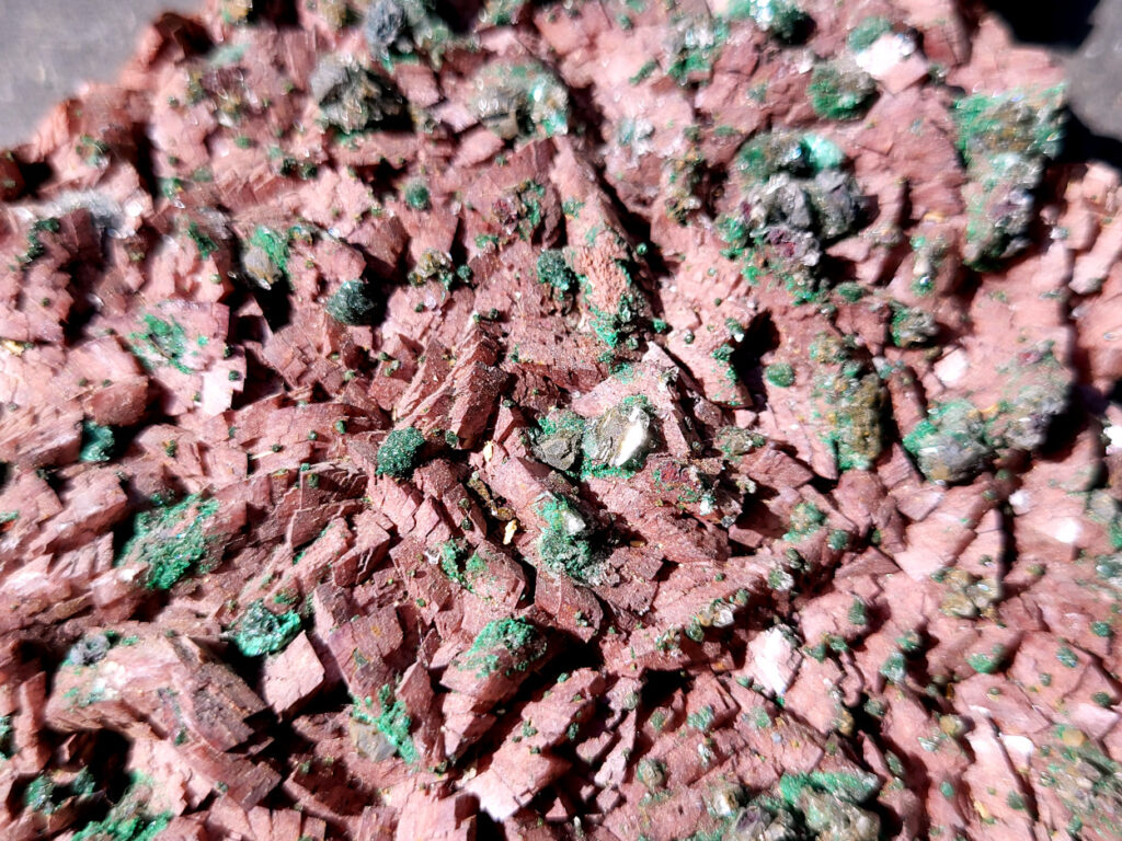 <strong>Malachiet op Dolemiet, 0,6kg, 16x11cm, 30,- euro, detailfoto, nr 4

Malachiet op Dolomiet, beschrijving

Dit kleurrijke exemplaar bevat blauwgroene rosasiet- en groene malachietkristallenaggregaties, bovenop een laag van donkerroodbruine ferroan dolomiet. Doorschijnende selenietkristallen zijn te vinden over de hele dolomiet, evenals die de rosasiet- en malachietkristalformaties omhullen.
Rosasiet is een secundair mineraal dat zich vormt in oxidatiezones van koper-zink afzettingen, waarbij doorgaans een vezelige botryoïdale bol ontstaat die glasachtig en zijdeachtig kan lijken. Hoewel ze doorgaans een blauwgroene kleur hebben, zijn kleurloze exemplaren niet ongehoord. De chemische formule van rosasiet is CuZnCO3(OH)2.

Over Malachiet:
Malachiet is een intens groen koperachtig mineraal dat in een grote verscheidenheid aan vormen voorkomt. Malachiet kan groeien in botryoïdale massa's, stalactietische formaties en reniforme formaties, meestal als een dichte cluster van waaierende vezelige naalden die een ogenschijnlijk vaste massa vormen. Naarmate lagen zich blijven opstapelen tijdens de vorming, kunnen soms gestreepte patronen vorm krijgen, wat de ringen in alle tinten groen verklaart die bij de meeste gepolijste malachietexemplaren te zien zijn.

Malachiet ontstaat door verwering van andere koperertsen en wordt zeer vaak gevonden in verband met andere koperhoudende mineralen zoals azuriet en chrysocolla. Het is te vinden in koperafzettingen over de hele wereld, maar de Democratische Republiek Congo is de belangrijkste bron voor gepolijste malachiet- en mineraalmonsters.

Malachiet wordt al sinds de oudheid gewaardeerd, eerst als utilitair kopererts en daarna als siersteen. Vanwege zijn waarde als decoratieve steen wordt het zelden nog als kopererts gewonnen.</strong>