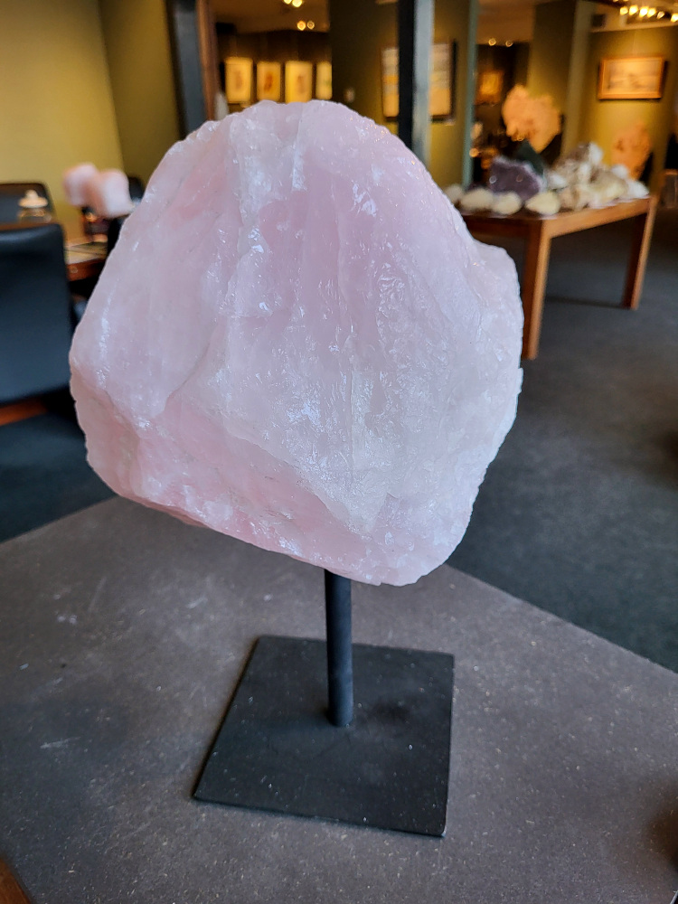Rozenkwarts op standaard, 11,6kg, 140,- euro, nr. 20

Rozenkwarts, beschrijving
Rozenkwarts is een roze variëteit van kwarts, bekend om zijn zachte, liefdevolle energie en wordt vaak geassocieerd met het hartchakra.
Kenmerken:
Rozenkwarts varieert in kleur van lichtroze tot diep roze, vaak met een doorschijnende of troebele textuur.
Het is een mineraal dat voornamelijk bestaat uit siliciumdioxide, met sporen van titanium, ijzer of mangaan die de roze kleur veroorzaken.
Herkomst:
Rozenkwarts wordt op veel plaatsen in de wereld gevonden, waaronder Brazilië, Madagaskar, Rusland, India en de VS, maar de kwaliteit kan variëren.
Eigenschappen en Betekenis:

Rozenkwarts staat bekend als de "steen van de liefde" en wordt geassocieerd met het openen van het hartchakra, het bevorderen van zelfliefde, vergeving, compassie en het aantrekken van liefdevolle relaties.
Bescherming:
In sommige overtuigingen wordt rozenkwarts ook gebruikt voor bescherming en het afweren van negatieve energieën.
Verzorging:
Rozenkwarts kan het beste niet langdurig aan direct zonlicht worden blootgesteld, omdat de kleur kan vervagen.