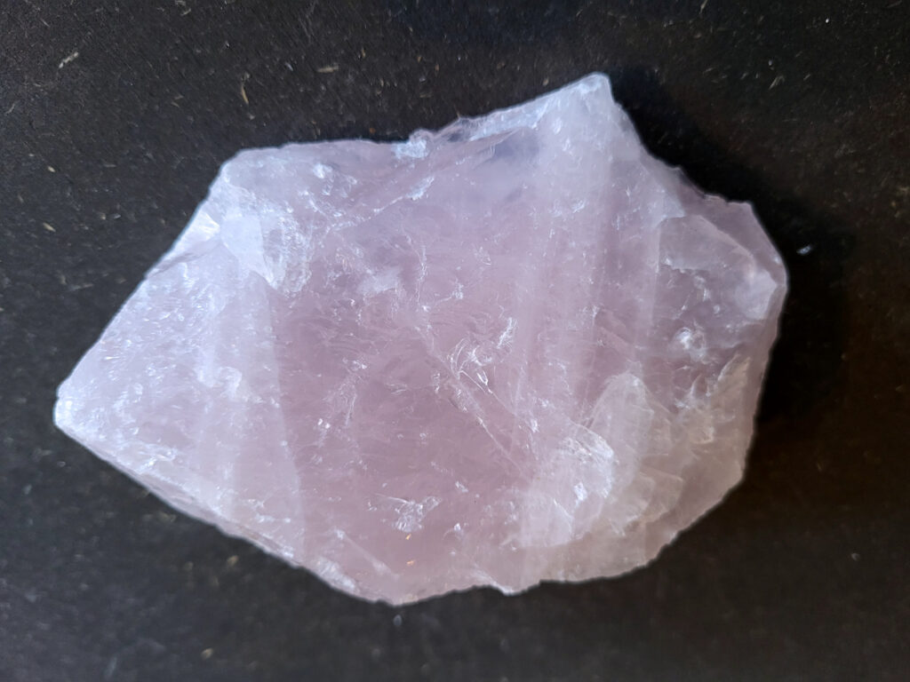 Rozenkwarts, 0,5kg, 5,- euro, nr. 4

Rozenkwarts, beschrijving
Rozenkwarts is een roze variëteit van kwarts, bekend om zijn zachte, liefdevolle energie en wordt vaak geassocieerd met het hartchakra.
Kenmerken:
Rozenkwarts varieert in kleur van lichtroze tot diep roze, vaak met een doorschijnende of troebele textuur.
Het is een mineraal dat voornamelijk bestaat uit siliciumdioxide, met sporen van titanium, ijzer of mangaan die de roze kleur veroorzaken.
Herkomst:
Rozenkwarts wordt op veel plaatsen in de wereld gevonden, waaronder Brazilië, Madagaskar, Rusland, India en de VS, maar de kwaliteit kan variëren.
Eigenschappen en Betekenis:

Rozenkwarts staat bekend als de "steen van de liefde" en wordt geassocieerd met het openen van het hartchakra, het bevorderen van zelfliefde, vergeving, compassie en het aantrekken van liefdevolle relaties.
Bescherming:
In sommige overtuigingen wordt rozenkwarts ook gebruikt voor bescherming en het afweren van negatieve energieën.
Verzorging:
Rozenkwarts kan het beste niet langdurig aan direct zonlicht worden blootgesteld, omdat de kleur kan vervagen.
