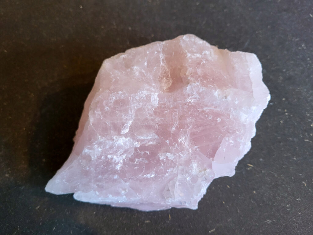 Rozenkwarts, 1,1kg, 11,- euro, nr. 2

Rozenkwarts, beschrijving
Rozenkwarts is een roze variëteit van kwarts, bekend om zijn zachte, liefdevolle energie en wordt vaak geassocieerd met het hartchakra.
Kenmerken:
Rozenkwarts varieert in kleur van lichtroze tot diep roze, vaak met een doorschijnende of troebele textuur.
Het is een mineraal dat voornamelijk bestaat uit siliciumdioxide, met sporen van titanium, ijzer of mangaan die de roze kleur veroorzaken.
Herkomst:
Rozenkwarts wordt op veel plaatsen in de wereld gevonden, waaronder Brazilië, Madagaskar, Rusland, India en de VS, maar de kwaliteit kan variëren.
Eigenschappen en Betekenis:

Rozenkwarts staat bekend als de "steen van de liefde" en wordt geassocieerd met het openen van het hartchakra, het bevorderen van zelfliefde, vergeving, compassie en het aantrekken van liefdevolle relaties.
Bescherming:
In sommige overtuigingen wordt rozenkwarts ook gebruikt voor bescherming en het afweren van negatieve energieën.
Verzorging:
Rozenkwarts kan het beste niet langdurig aan direct zonlicht worden blootgesteld, omdat de kleur kan vervagen.