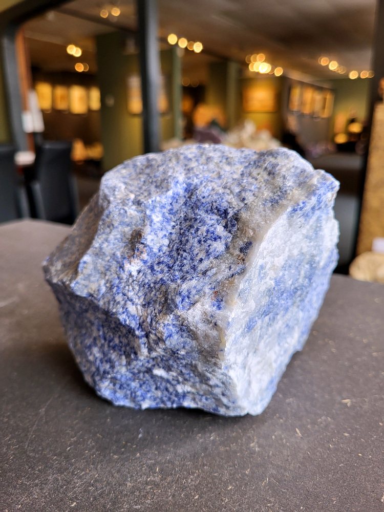 <strong>Sodaliet, ruw, 2 kg, 14,- euro, nr. 8,

Sodaliet, beschrijving,
Sodaliet is een diepblauwe edelsteen en mineraal, bekend om zijn helderheid, spirituele betekenis en helende eigenschappen.
Sodaliet is een natrium-aluminiumsilicaat dat behoort tot de veldspaatmineralen en vaak witte aders of vlekken bevat, hoewel de mooiste kwaliteit inktblauw en zonder aders is (Sodaliet kan ook groen, rood of roze zijn afhankelijk van de samenstelling) . De steen heeft een hardheid van ongeveer 5,5–6 op de schaal van Mohs, een glasachtige tot matte glans en een gemiddelde dichtheid van 2,3–2,4 g/cm³. De naam sodaliet is afgeleid van het Engelse sodium (natrium) en het Griekse lithos (steen).  
Geschiedenis en gebruik
Sodaliet werd voor het eerst ontdekt in Zuid-Amerika, met name in Chili, en later ook in Brazilië en Uruguay. Het werd al snel populair als edelsteen en decoratief materiaal, gebruikt in sieraden, beeldjes, schalen en zelfs als blauwe verf of oogmake-up in de oudheid  Oude culturen zoals de Egyptenaren, Grieken en Romeinen waardeerden sodaliet om zijn beschermende en concentratie bevorderende eigenschappen . 
Spirituele en helende eigenschappen
Sodaliet staat bekend als de Steen van de Denker en wordt geassocieerd met rationaliteit, objectiviteit, intuïtie en innerlijke waarheid. Het helpt bij het structureren van gedachten, helder communiceren en zelfvertrouwen, en bevordert rust en focus tijdens werk, studie of meditatie  Spiritueel opent sodaliet het derde oogchakra, versterkt intuïtie en ondersteunt inzichtgevende meditaties. De steen wordt ook gebruikt om negatieve energie af te weren en harmonie in groepen te bevorderen. 
Fysieke voordelen
Fysiek kan sodaliet helpen bij keel-, hals- en stembandproblemen, het verlagen van bloeddruk, het ontspannen van nek en schouders, en het ondersteunen van het beenderstelsel en herstel van pezen  Dankzij het natriumgehalte heeft sodaliet ook een desinfecterende werking. 
Toepassingen
Sodaliet wordt vaak gebruikt in sieraden zoals kettingen, ringen en oorbellen, maar ook voor decoratieve objecten, houtsnijwerk en wandbedekking Het past goed bij de sterrenbeelden Boogschutter en Maagd, en kan helpen bij het vinden van focus, richting en zelfvertrouwen. 
Al met al is sodaliet een veelzijdige steen die zowel mentaal, emotioneel, fysiek als spiritueel ondersteuning biedt en geliefd is om zijn schoonheid en krachtige energetische eigenschappen.
</strong>