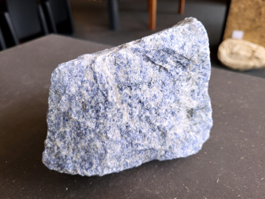 <strong>Sodaliet, ruw, 2,1 kg, 14,- euro, nr. 5

Sodaliet, beschrijving,
Sodaliet is een diepblauwe edelsteen en mineraal, bekend om zijn helderheid, spirituele betekenis en helende eigenschappen.
Sodaliet is een natrium-aluminiumsilicaat dat behoort tot de veldspaatmineralen en vaak witte aders of vlekken bevat, hoewel de mooiste kwaliteit inktblauw en zonder aders is (Sodaliet kan ook groen, rood of roze zijn afhankelijk van de samenstelling) . De steen heeft een hardheid van ongeveer 5,5–6 op de schaal van Mohs, een glasachtige tot matte glans en een gemiddelde dichtheid van 2,3–2,4 g/cm³. De naam sodaliet is afgeleid van het Engelse sodium (natrium) en het Griekse lithos (steen).  
Geschiedenis en gebruik
Sodaliet werd voor het eerst ontdekt in Zuid-Amerika, met name in Chili, en later ook in Brazilië en Uruguay. Het werd al snel populair als edelsteen en decoratief materiaal, gebruikt in sieraden, beeldjes, schalen en zelfs als blauwe verf of oogmake-up in de oudheid  Oude culturen zoals de Egyptenaren, Grieken en Romeinen waardeerden sodaliet om zijn beschermende en concentratie bevorderende eigenschappen . 
Spirituele en helende eigenschappen
Sodaliet staat bekend als de Steen van de Denker en wordt geassocieerd met rationaliteit, objectiviteit, intuïtie en innerlijke waarheid. Het helpt bij het structureren van gedachten, helder communiceren en zelfvertrouwen, en bevordert rust en focus tijdens werk, studie of meditatie  Spiritueel opent sodaliet het derde oogchakra, versterkt intuïtie en ondersteunt inzichtgevende meditaties. De steen wordt ook gebruikt om negatieve energie af te weren en harmonie in groepen te bevorderen. 
Fysieke voordelen
Fysiek kan sodaliet helpen bij keel-, hals- en stembandproblemen, het verlagen van bloeddruk, het ontspannen van nek en schouders, en het ondersteunen van het beenderstelsel en herstel van pezen  Dankzij het natriumgehalte heeft sodaliet ook een desinfecterende werking. 
Toepassingen
Sodaliet wordt vaak gebruikt in sieraden zoals kettingen, ringen en oorbellen, maar ook voor decoratieve objecten, houtsnijwerk en wandbedekking Het past goed bij de sterrenbeelden Boogschutter en Maagd, en kan helpen bij het vinden van focus, richting en zelfvertrouwen. 
Al met al is sodaliet een veelzijdige steen die zowel mentaal, emotioneel, fysiek als spiritueel ondersteuning biedt en geliefd is om zijn schoonheid en krachtige energetische eigenschappen.
</strong>