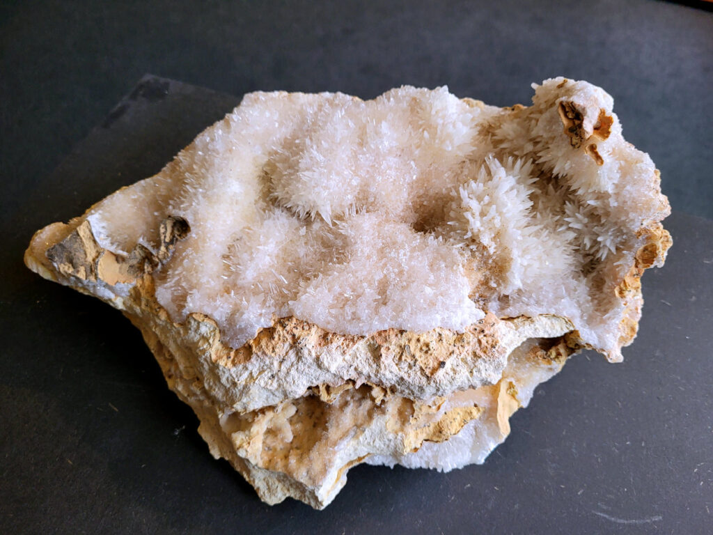 Hondentanden Calciet, 4,4kg, 96,- euro, nr. 3

Hondentandcalciet, beschrijving

Hondentandcalciet, ook wel Starburst calciet genoemd, is een vorm van calciet die bekend staat om zijn unieke, ruwe kristalstructuur die lijkt op hondentanden of varkensstanden. Het wordt gewaardeerd om zijn zachte, heldere uitstraling en wordt vaak gevonden in combinatie met andere mineralen zoals fluoriet. 
Kenmerken van Hondentandcalciet:
Kristalstructuur:
De kristallen zijn grillig, puntig en helder gevormd, wat een ruwe, natuurlijke uitstraling geeft. 
Kleur:
Meestal wit of licht van kleur, soms met bruine tinten of bedekt met andere mineralen zoals fluoriet. 
Energie:
Bekend om zijn zachte, lichtkracht en wordt geassocieerd met diepe transformaties en het openen van het bewustzijn. 
Vormen:
Te vinden in ruwe, onbewerkte vormen, maar ook op standaard of in combinatie met andere mineralen. 
Spiritueel:
Wordt gebruikt voor spirituele doeleinden, zoals meditatie en het openen van het bewustzijn. 
