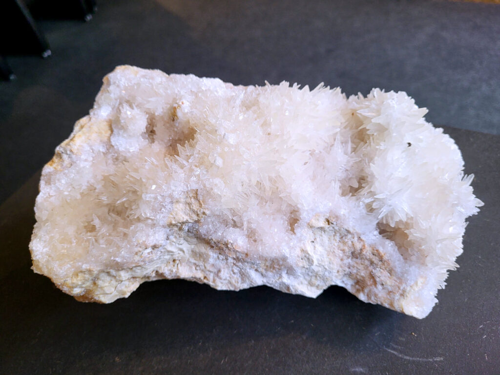 Hondentanden Calciet, 5kg, 105,- euro, nr. 2

Hondentandcalciet, beschrijving

Hondentandcalciet, ook wel Starburst calciet genoemd, is een vorm van calciet die bekend staat om zijn unieke, ruwe kristalstructuur die lijkt op hondentanden of varkensstanden. Het wordt gewaardeerd om zijn zachte, heldere uitstraling en wordt vaak gevonden in combinatie met andere mineralen zoals fluoriet. 
Kenmerken van Hondentandcalciet:
Kristalstructuur:
De kristallen zijn grillig, puntig en helder gevormd, wat een ruwe, natuurlijke uitstraling geeft. 
Kleur:
Meestal wit of licht van kleur, soms met bruine tinten of bedekt met andere mineralen zoals fluoriet. 
Energie:
Bekend om zijn zachte, lichtkracht en wordt geassocieerd met diepe transformaties en het openen van het bewustzijn. 
Vormen:
Te vinden in ruwe, onbewerkte vormen, maar ook op standaard of in combinatie met andere mineralen. 
Spiritueel:
Wordt gebruikt voor spirituele doeleinden, zoals meditatie en het openen van het bewustzijn. 
