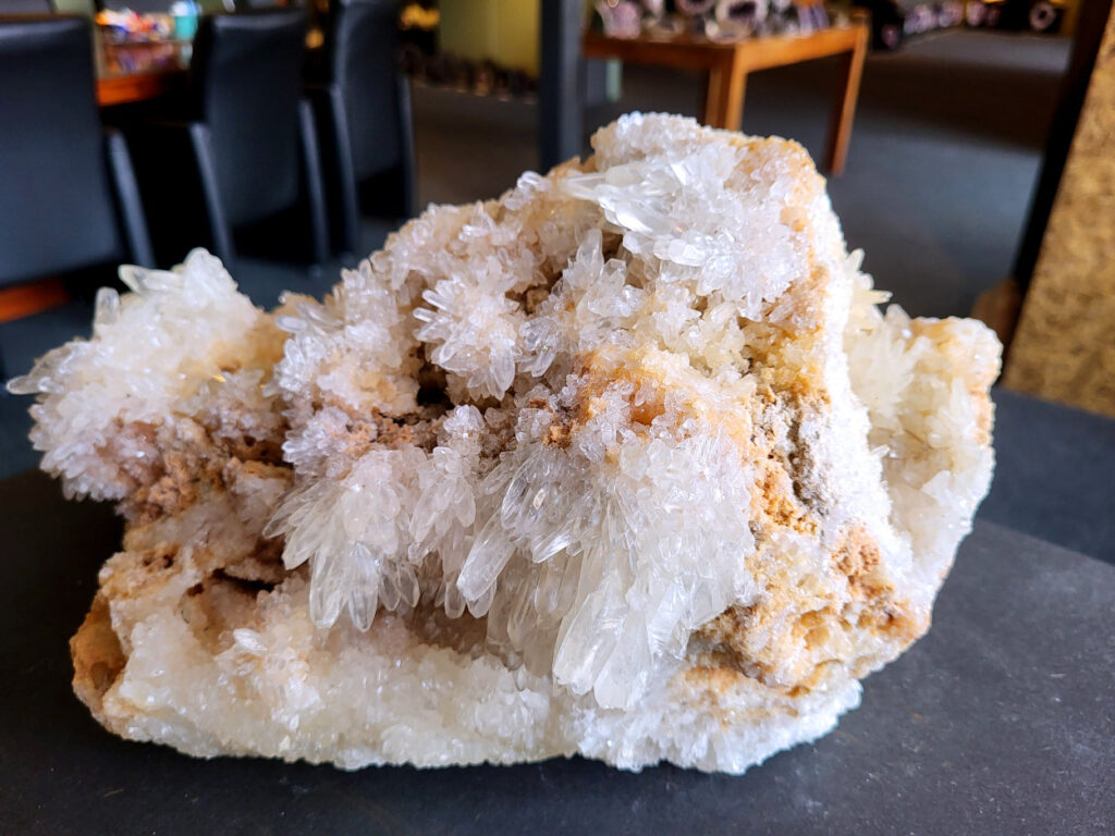 Hondentandencalciet, 8,7 kg, 190,- euro, nr. 48

Hondentandcalciet, beschrijving

Hondentandcalciet, ook wel Starburst calciet genoemd, is een vorm van calciet die bekend staat om zijn unieke, ruwe kristalstructuur die lijkt op hondentanden of varkensstanden. Het wordt gewaardeerd om zijn zachte, heldere uitstraling en wordt vaak gevonden in combinatie met andere mineralen zoals fluoriet. 
Kenmerken van Hondentandcalciet:
Kristalstructuur:
De kristallen zijn grillig, puntig en helder gevormd, wat een ruwe, natuurlijke uitstraling geeft. 
Kleur:
Meestal wit of licht van kleur, soms met bruine tinten of bedekt met andere mineralen zoals fluoriet. 
Energie:
Bekend om zijn zachte, lichtkracht en wordt geassocieerd met diepe transformaties en het openen van het bewustzijn. 
Vormen:
Te vinden in ruwe, onbewerkte vormen, maar ook op standaard of in combinatie met andere mineralen. 
Spiritueel:
Wordt gebruikt voor spirituele doeleinden, zoals meditatie en het openen van het bewustzijn. 