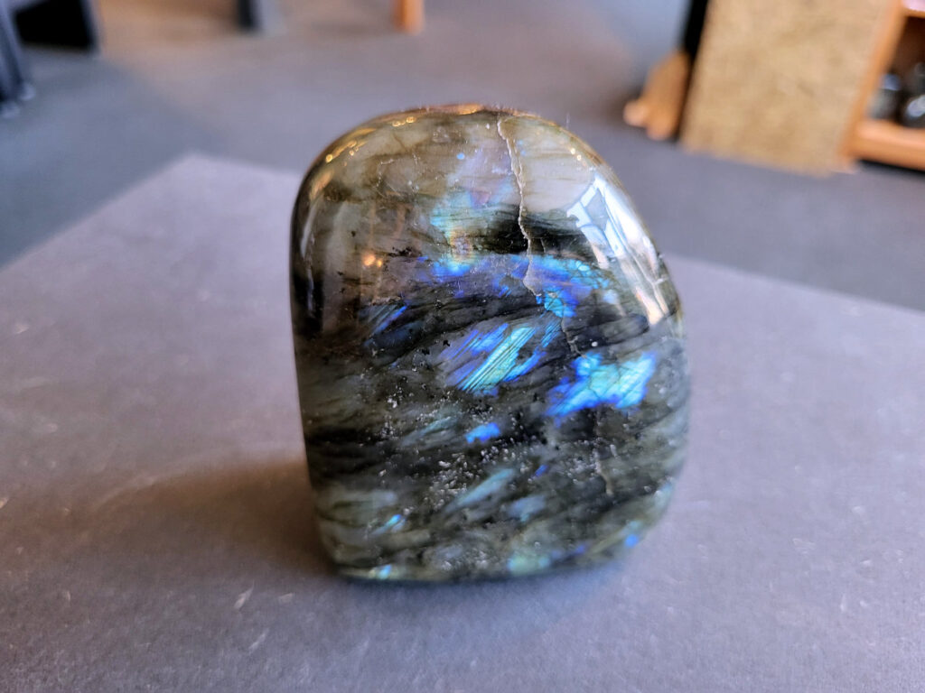Labradoriet, 9cm hoog, 11,- euro, nr. 41

Labradoriet, beschrijving
Labradoriet is een edelsteen die bekend staat om zijn iriserende kleurenspel, ook wel labradoriseren genoemd, dat vaak doet denken aan het noorderlicht. Het is een populaire steen in de edelstenenwereld vanwege zowel zijn uiterlijk als zijn vermeende spirituele eigenschappen.
Wat is labradoriet?
Labradoriet is een veldspaatmineraal dat wordt gekenmerkt door een opaalachtig glans of iriserend effect, veroorzaakt door de lichtbreking in de interne structuur van de steen.
De meest voorkomende kleur is grijs of groenachtig grijs, maar de steen kan ook blauwe, gele, oranje, paarse of zelfs rode flitsen laten zien.
De steen is genoemd naar het Canadese schiereiland Labrador, waar het voor het eerst werd ontdekt.
Spirituele betekenis en eigenschappen:
Labradoriet wordt vaak beschouwd als een beschermende steen, vooral voor mensen die gevoelig zijn voor de energieën van hun omgeving.
Het zou helpen bij het versterken van de aura en het verminderen van energielekkage, waardoor je je weerbaarder voelt.
Labradoriet wordt geassocieerd met het versterken van intuïtie, het vergroten van het bewustzijn en het transformeren van negatieve energieën.
Het wordt ook gebruikt om blokkades op te heffen en de innerlijke wijsheid te onthullen.
Gebruik:
Labradoriet wordt vaak verwerkt in sieraden zoals hangers, armbanden en oorbellen.
Het kan ook als ruwe steen, knuffelsteen of in andere vormen worden gebruikt, bijvoorbeeld in een huis of op een werkplek.
Labradoriet kan worden gereinigd door het onder stromend water te houden of door het te reinigen met een andere steen zoals bergkristal of seleniet.
Vindplaatsen:
Labradoriet wordt gevonden op verschillende locaties over de hele wereld, waaronder Canada, Finland, Madagaskar en Rusland.
-Kunstgalerie Arnold-
