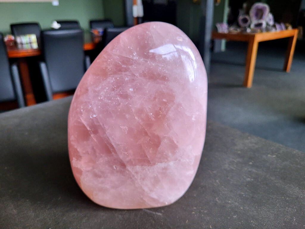 Rozenkwarts, sculptuur, 2,6 kg, 35 euro, nr. 10

Rozenkwarts, beschrijving
Rozenkwarts is een roze variëteit van kwarts, bekend om zijn zachte, liefdevolle energie en wordt vaak geassocieerd met het hartchakra.
Kenmerken:
Rozenkwarts varieert in kleur van lichtroze tot diep roze, vaak met een doorschijnende of troebele textuur.
Het is een mineraal dat voornamelijk bestaat uit siliciumdioxide, met sporen van titanium, ijzer of mangaan die de roze kleur veroorzaken.
Herkomst:
Rozenkwarts wordt op veel plaatsen in de wereld gevonden, waaronder Brazilië, Madagaskar, Rusland, India en de VS, maar de kwaliteit kan variëren.
Eigenschappen en Betekenis:

Rozenkwarts staat bekend als de "steen van de liefde" en wordt geassocieerd met het openen van het hartchakra, het bevorderen van zelfliefde, vergeving, compassie en het aantrekken van liefdevolle relaties.
Bescherming:
In sommige overtuigingen wordt rozenkwarts ook gebruikt voor bescherming en het afweren van negatieve energieën.
Verzorging:
Rozenkwarts kan het beste niet langdurig aan direct zonlicht worden blootgesteld, omdat de kleur kan vervagen.
-kunstgalerie-arnold-